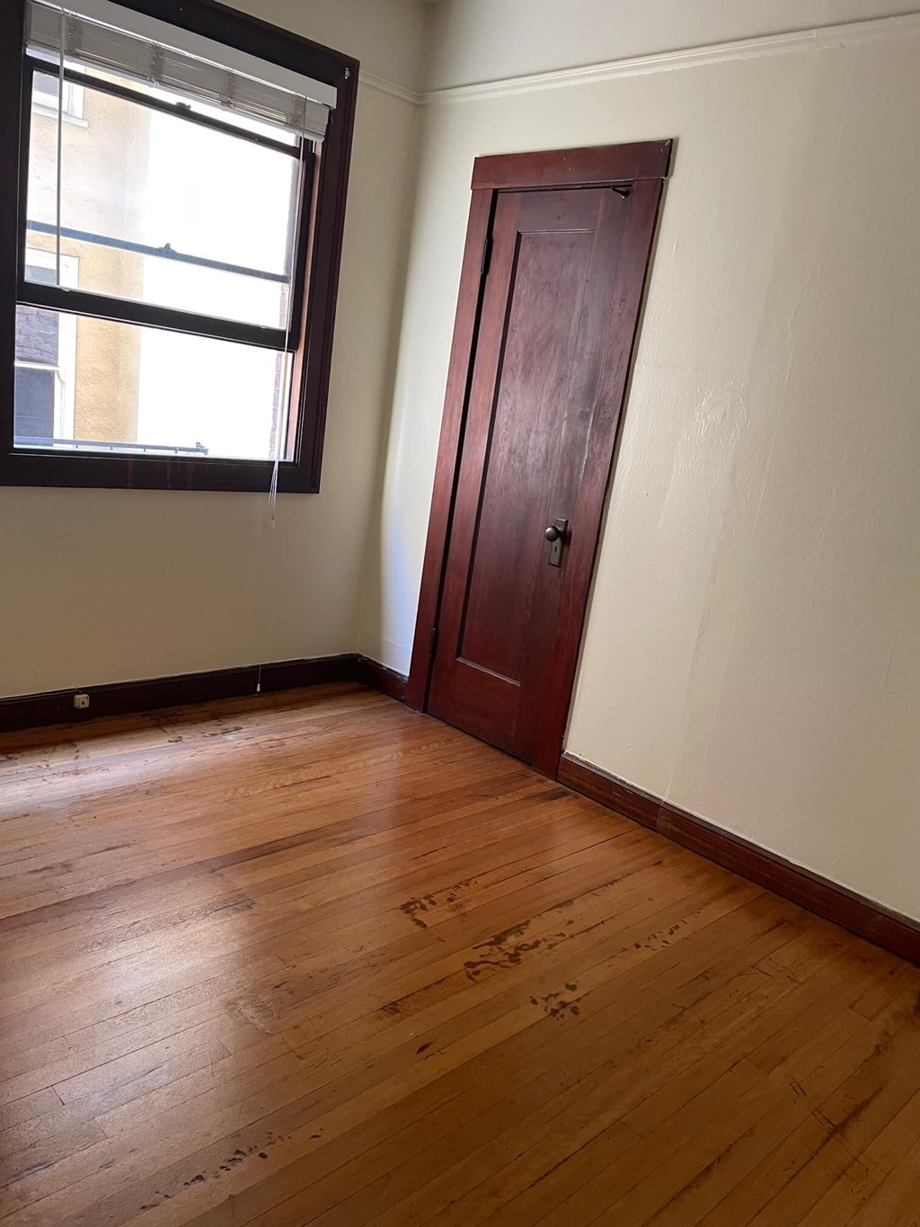 a room with a wooden floor and a door to a window